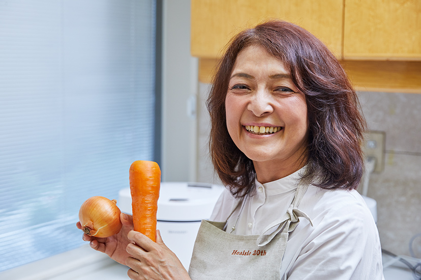 写真：野菜を持って笑う勝間さん